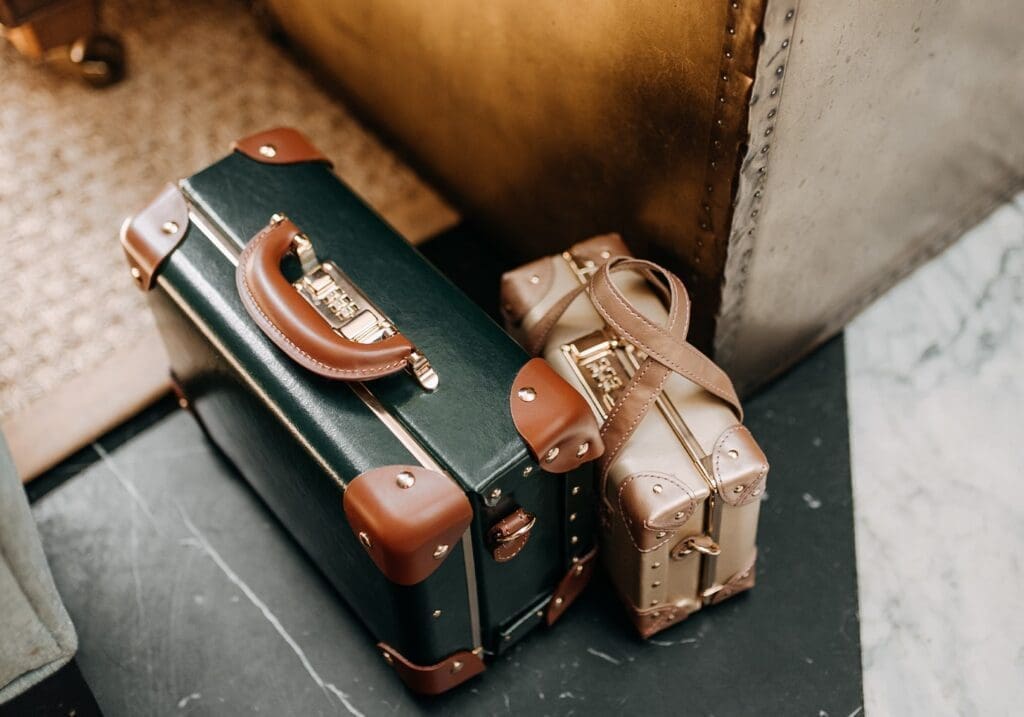 Two old-fashioned suitcase bags, one green, the other gold
