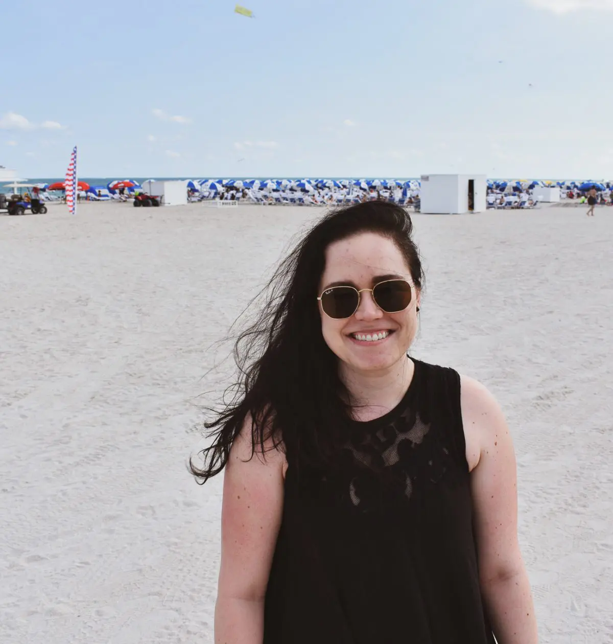 Christine Csencsitz standing on the beach with a Free People top, J. Crew shorts, and a Madewell purse.