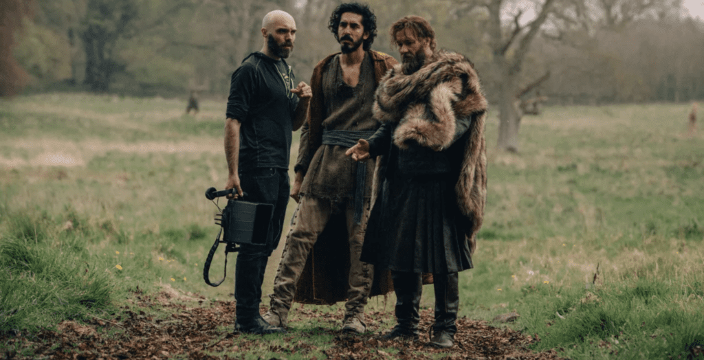 David-Lowery-Dev-Patel-and-Joel-Edgerton-on-the-set-of-The-Green-Knight.Photo-Eric-Zachanowich-A24-Films- - Cats & Coffee