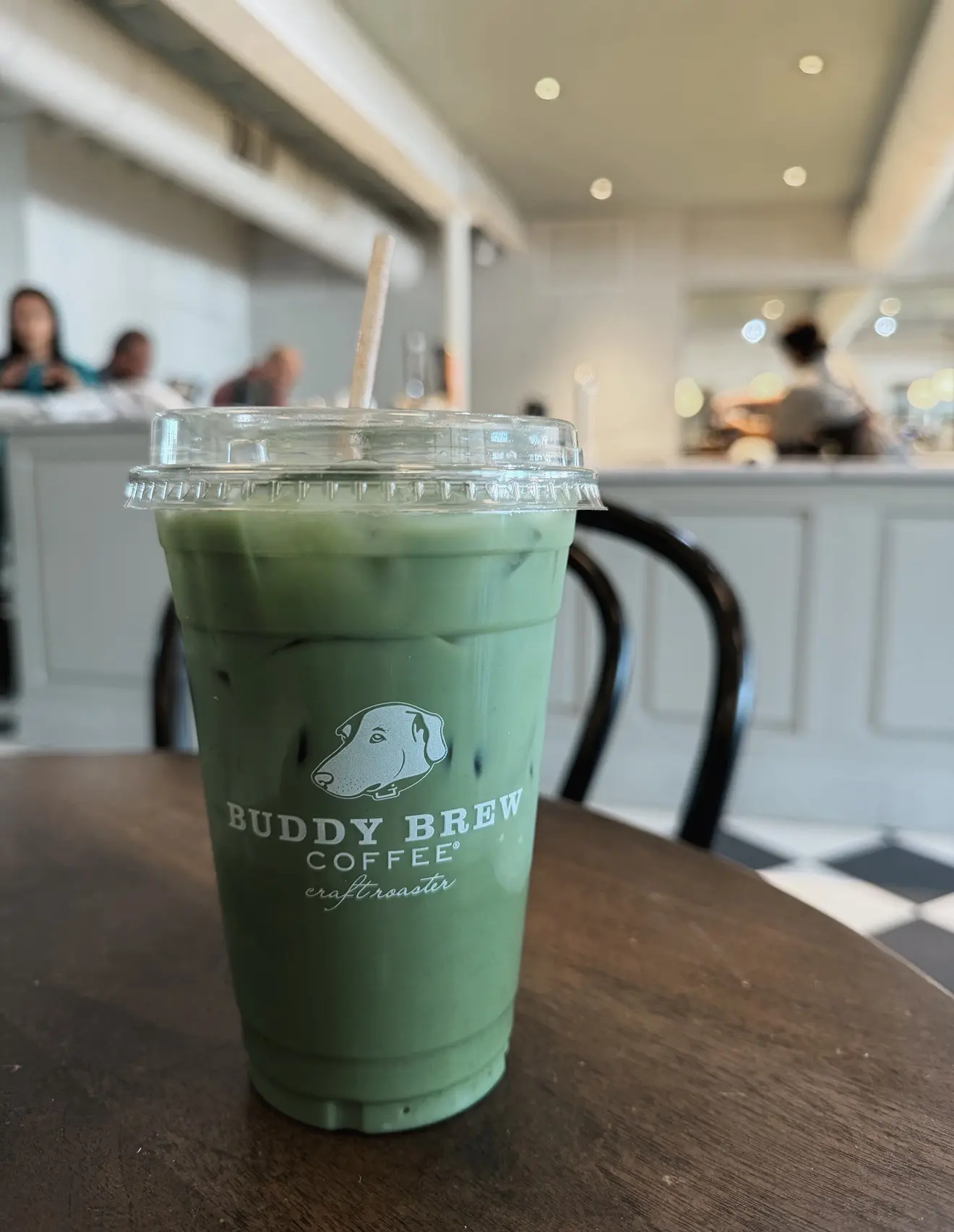 Screenshot - Cats & Coffee Cold green tea/coffee beverage in a clear plastic cup with a straw at a cafe; Buddy Brew logo visible on cup.