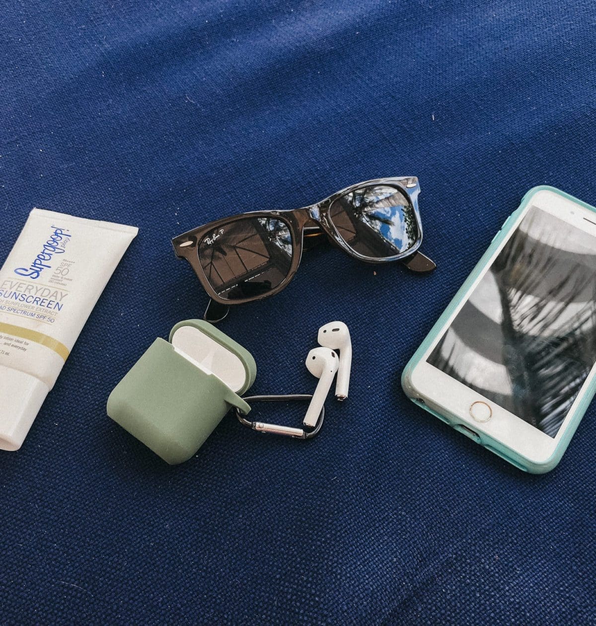 Air pods, sunglasses, cell phone, and sunscreen.