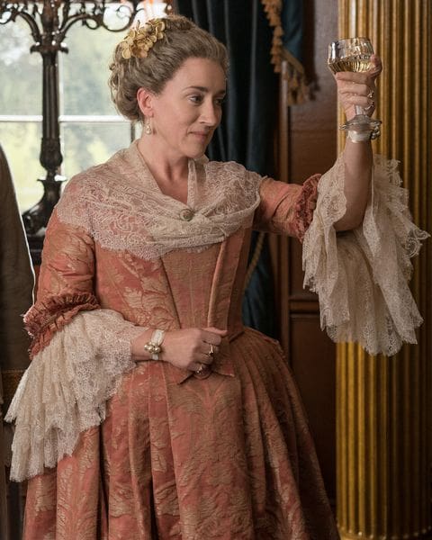 Jocasta Cameron from Outlander Season 4, played by Maria Doyle Kennedy, in a peach and gold gown with lace detailing. 