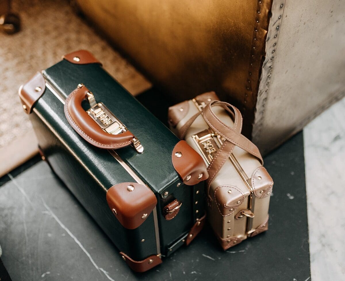 Two old-fashioned suitcase bags, one green, the other gold
